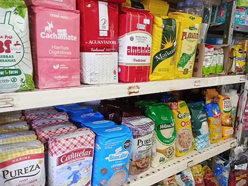 Una estantería con varios productos alimenticios que se venden en una tienda.